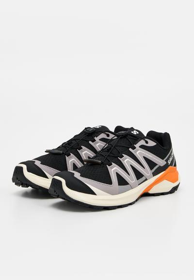 Paire de chaussures de trail Salomon noires, grises et orange avec système de laçage rapide et semelle robuste pour une utilisation en extérieur.