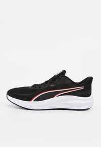 Chaussure de course noire et blanche avec des détails de rayures rouges et blanches, empeigne en mesh, lacets et semelle coussinée, vue de côté sur fond uni.
