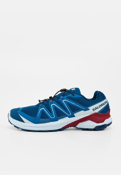 Chaussure de trail Salomon bleu et blanc avec des accents rouges, tige en mesh et système de laçage rapide, vue du côté extérieur.
