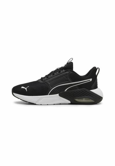 Chaussures de sport noires avec tige en mesh, semelle blanche, présentant un orteil arrondi, des accents texturés et une unité d'air visible au niveau du talon.