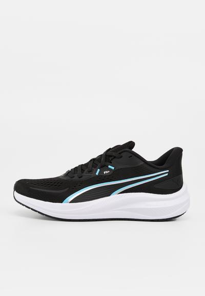 Chaussure de course noire et bleue avec semelle blanche, dessus en mesh, col rembourré et fermeture à lacets, montrée de profil sur fond blanc.
