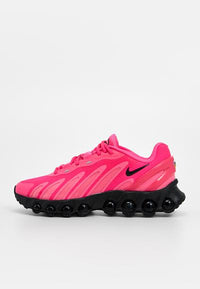 Chaussures de sport roses avec une tige en mesh texturé, un design incurvé, une semelle noire avec des éléments de rembourrage ronds, et un logo Nike noir.