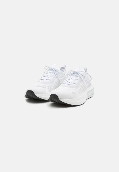 Des chaussures de sport blanches avec une tige en maille texturée, un laçage à l'avant et une semelle en caoutchouc noire. Les accents comprennent des détails gris sur les côtés.