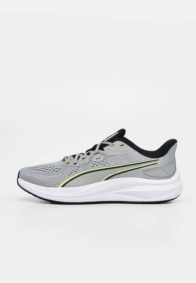 Chaussure de course grise avec des touches noires et jaunes, des lacets noirs, une semelle blanche amortie et une tige en mesh, présentée de profil sur fond blanc.