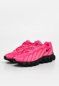 Chaussures de sport roses avec une tige texturée, dotées d'une semelle noire avec des coussinets arrondis pour l'amorti et des accents réfléchissants. Design à lacets.