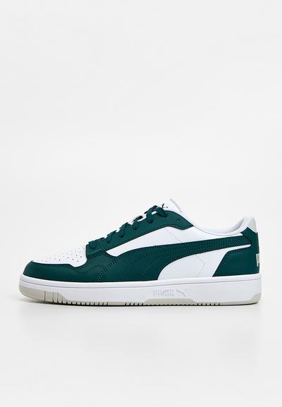 Baskets vertes et blanches en cuir texturé et mesh, avec embout perforé, lacets plats, et un logo discret sur le talon.
