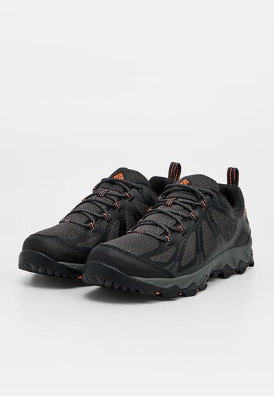 Paire de chaussures de trail noires et grises avec des accents orange, semelles texturées et design à lacets sur fond blanc uni.