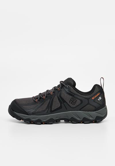 Chaussure de randonnée Columbia noire et grise avec tige en mesh, fermeture à lacets, semelle robuste et petits détails du logo orange sur le côté et la bride au talon.