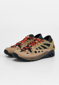 Chaussures de randonnée légères avec une tige en maille beige, des accents noirs et des lacets rouges. Semelles texturées offrant adhérence et stabilité.