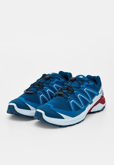 Paire de chaussures de sport bleu et blanc avec des accents rouges, tissu en mesh et système de laçage rapide, placées côte à côte sur un fond uni.