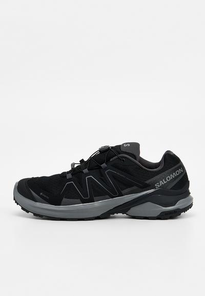 Chaussure de trail Salomon noire et grise avec Gore-Tex, système de laçage rapide et semelle texturée pour une adhérence hors route.
